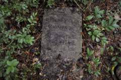 Toppled grave marker for Burney L. Cooper Jr.